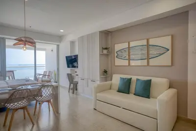 a living room with a couch and a dining room at Beachfront Studio with Stunning Ocean Views in Cartagena de Indias