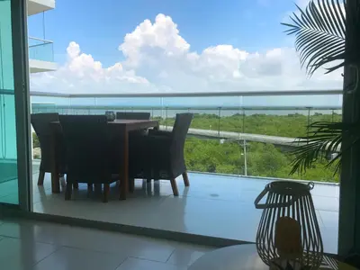 a table and chairs on a balcony with a view of the ocean at Morros Suites Apartamentos in Cartagena de Indias
