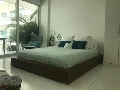a bedroom with a large bed with blue and white pillows at Morros Suites Apartamentos in Cartagena de Indias