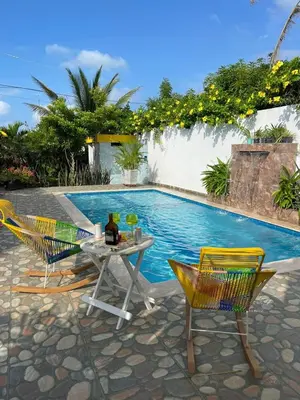 a table and chairs next to a swimming pool at Cabaña Julianita in Santa Veronica