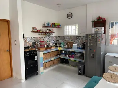 a kitchen with a counter and a stove and a refrigerator at Cabaña Julianita in Santa Veronica