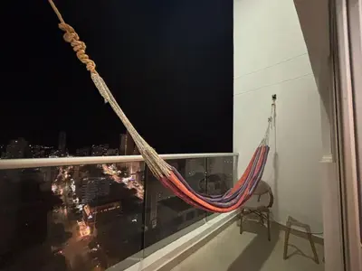 a hammock on a window with a view of a city at Apartamento Magno Loft Bocagrande in Cartagena de Indias