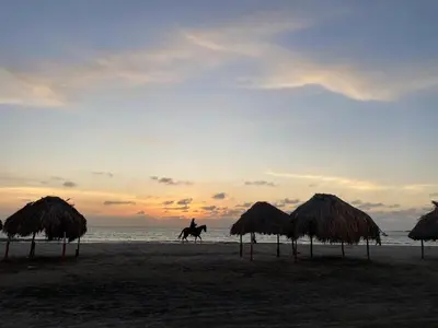 a person riding a horse on the beach at sunset at Casa Española del Mar in Cartagena de Indias