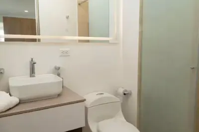 a bathroom with a sink and a toilet and a mirror at Loft apartment with sea view in Cartagena de Indias