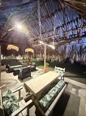 a pavilion with a picnic table and a straw roof at Cabaña Las Tres Palmas in San Bernardo del Viento in San Bernardo del Viento