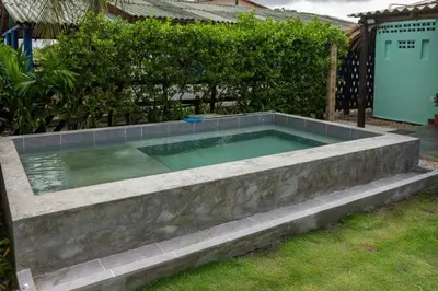 a swimming pool in a garden with a fence at Cabaña Las Tres Palmas in San Bernardo del Viento in San Bernardo del Viento
