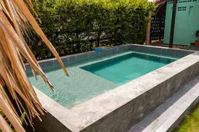 a swimming pool with a stone wall around it at Cabaña Las Tres Palmas in San Bernardo del Viento in San Bernardo del Viento