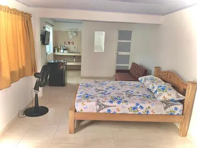a bedroom with a bed and a living room at Hostal La FLora in Cartagena de Indias