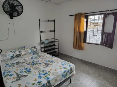 a bedroom with a bed and a window at Hostal La FLora in Cartagena de Indias