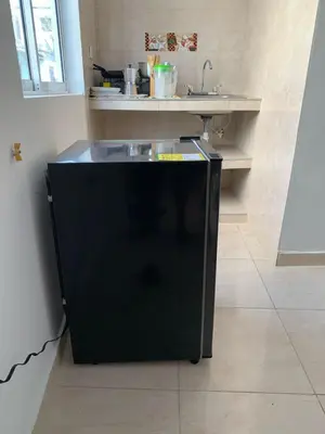 a black refrigerator in a kitchen with a sink at Hostal La FLora in Cartagena de Indias