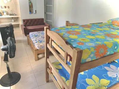 a bedroom with a bed with a flowered sheet and a vacuum at Hostal La FLora in Cartagena de Indias