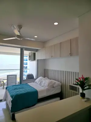a bedroom with a bed with a blue blanket at Cartagena Beach Exclusive apto in Cartagena de Indias