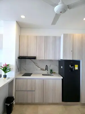 a kitchen with a black refrigerator and wooden cabinets at Cartagena Beach Exclusive apto in Cartagena de Indias