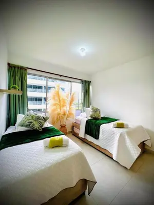 a bedroom with two beds and a large window at Serenity Flat in Puerto Tierrabaja
