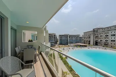 a balcony with a swimming pool in a building at Mágico Oasis en Baia Kristal Vista a la Laguna 2BR in Los Arrayanes