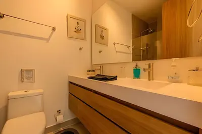 a bathroom with a toilet and a sink and a mirror at Mágico Oasis en Baia Kristal Vista a la Laguna 2BR in Los Arrayanes