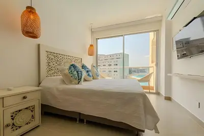 a bedroom with a bed and a large window at Mágico Oasis en Baia Kristal Vista a la Laguna 2BR in Los Arrayanes