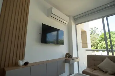 a living room with a flat screen tv on the wall at Con jacuzzi privado, laguna y Paddle board in Cartagena de Indias
