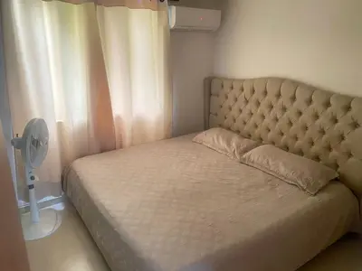 a bed in a bedroom with a fan next to a window at Apartamento en Villa Carolina in Barranquilla