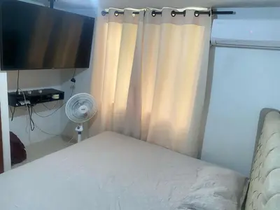 a bedroom with a bed with a curtain and a fan at Apartamento en Villa Carolina in Barranquilla