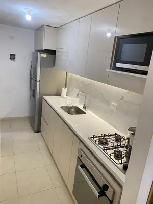 a white kitchen with a sink and a stove at Apartamento en Villa Carolina in Barranquilla