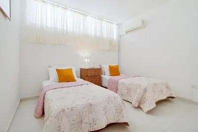 a bedroom with two beds with pink and yellow pillows at Apartamento comodo con excelente ubicacion in Cartagena de Indias