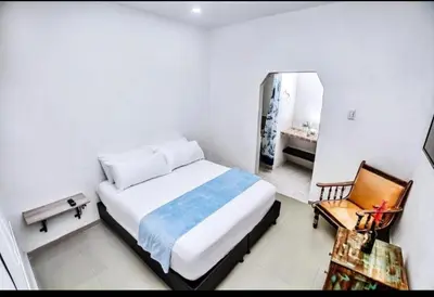 a bedroom with a bed and a chair and a mirror at casa real in Cartagena de Indias