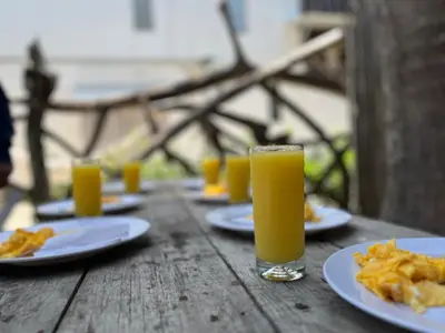 a table with plates of food and glasses of orange juice at La playita ocean view in Playa Blanca