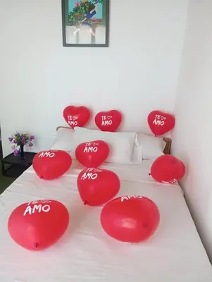 a bed with red pillows with the word ahmo on it at La playita ocean view in Playa Blanca