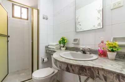 a white bathroom with a sink and a toilet at Habitaciones cerca playa Bocagrande in Cartagena de Indias
