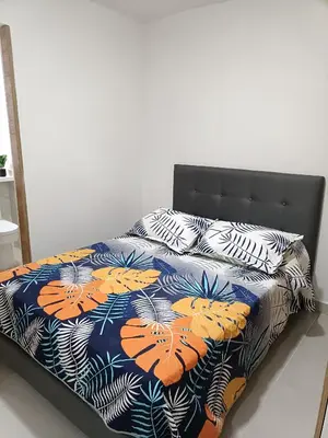 a bed with a blue and orange comforter and pillows at Torre 811 in Cartagena de Indias