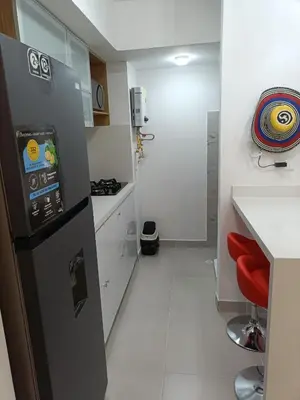 a kitchen with a black refrigerator and a red stool at Torre 811 in Cartagena de Indias