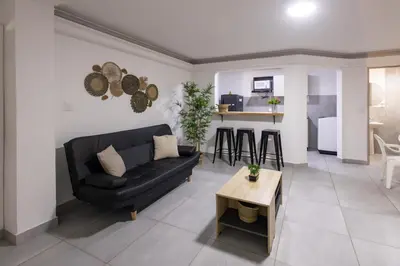 a living room with a black couch and a table at Cozy apartment in bocagrande in Cartagena de Indias