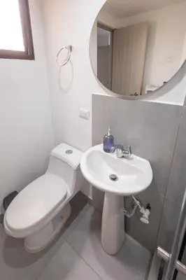 a bathroom with a toilet and a sink and a mirror at Cozy apartment in bocagrande in Cartagena de Indias