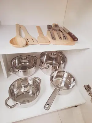 a shelf filled with silver bowls and utensils at Apartaestudio completo cerca Barranquilla in Galapa