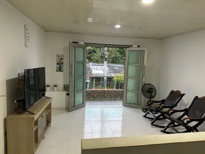 a living room with two chairs and a flat screen tv at Habitación en Santiago de Tolú in Santiago