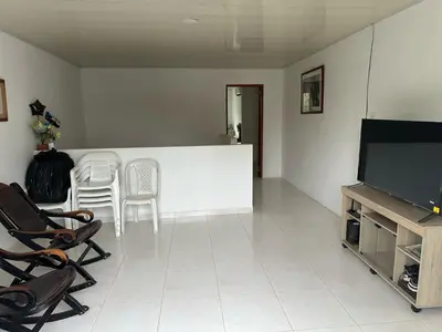 a living room with a flat screen tv and chairs at Habitación en Santiago de Tolú in Santiago