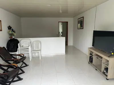 a living room with a flat screen tv and chairs at Habitación en Santiago de Tolú in Santiago