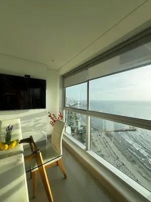 a dining room with a glass table and a large window at Apartamento Palmar in Cartagena de Indias