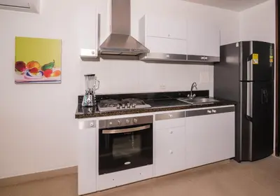 a kitchen with a stove and a refrigerator at Magico Apartamento Frente al Mar 3 Habitaciones MSC22 in Coveñas