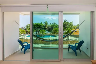 a room with a hammock and a view of a pool at Magico Apartamento Frente al Mar 3 Habitaciones MSC22 in Coveñas