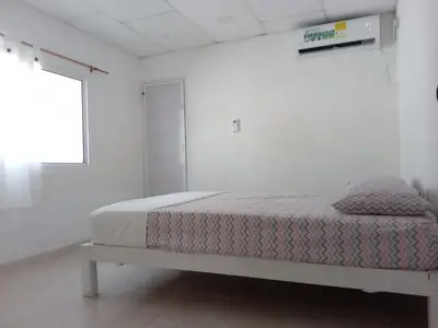 a bed in a white room with a window at Cabaña MARDELA Casa de Playa in San Antero