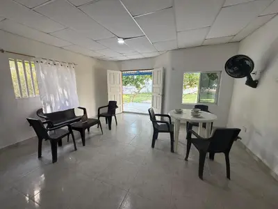 a living room with chairs and a table and a window at Cabaña MARDELA Casa de Playa in San Antero