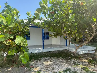 a house with a tree in front of it at Cabaña MARDELA Casa de Playa in San Antero