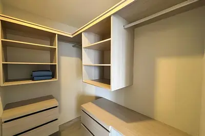 a walk in closet with white cabinets and wooden shelves at Dominique in Cartagena de Indias
