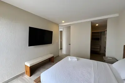 a bedroom with a bed and a tv on the wall at Dominique in Cartagena de Indias