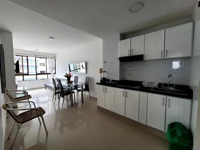 a kitchen with white cabinets and a table and chairs at Live Stay - Cartagena Escape Plaza in Cartagena de Indias
