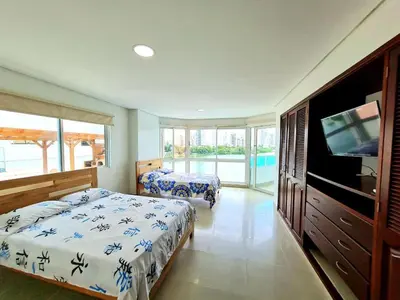 a bedroom with two beds and a flat screen tv at Apartamento con la mejor vista Cartagena in Cartagena de Indias