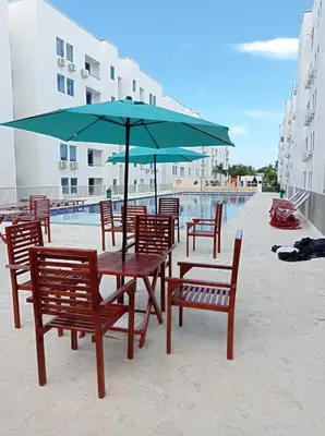 a table and chairs with an umbrella next to a pool at Coveñas Family Haven in Coveñas