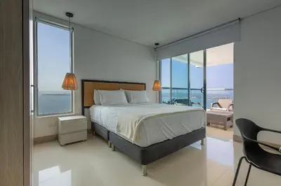 a bedroom with a bed with a view of the ocean at Laurhomes Laguito Floor 33, 3HBT in Cartagena de Indias